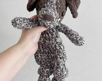 May include: A brown and white crocheted dog plush toy with a brown nose and black eyes. The toy is made with a textured yarn and has a loopy couture label on the bottom.
