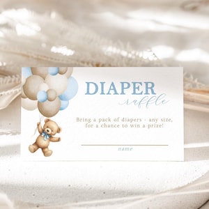 May include: A blue and brown baby shower diaper raffle ticket with a teddy bear holding balloons. The text reads "DIAPER raffle Bring a pack of diapers - any size, for a chance to win a prize! name"