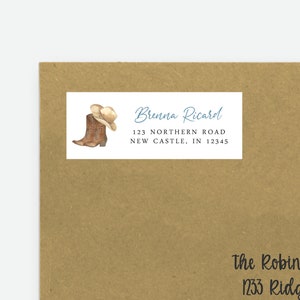 May include: A brown paper envelope with a white label addressed to Brenna Ricard at 123 Northern Road, New Castle, IN 12345. The label features a watercolor illustration of a brown cowboy boot with a white cowboy hat. The envelope also has a handwritten address to The Robinson Family at 1233 Ridgeway Rd., Zkingman, KS 12345.