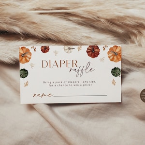 May include: A white card with a brown border and a pumpkin theme. The text on the card reads "DIAPER raffle" and "Bring a pack of diapers - any size, for a chance to win a prize!" There is a line for a name at the bottom of the card.