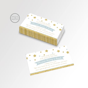 May include: A white card with gold glitter stars and a blue banner that says "Please bring a book" instead of a card. The card is a request for guests to bring a book instead of a card to a baby shower.