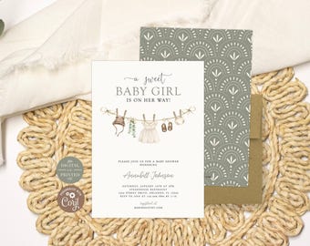 Puede incluir: Una tarjeta de invitación para baby shower con el texto A sweet BABY GIRL IS ON HER WAY! y una ilustración en acuarela de ropa de bebé en un tendedero. Incluye los detalles del evento para Annabell Johnson y un sobre verde salvia.