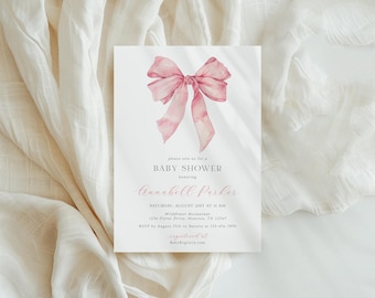 May include: A white rectangular baby shower invitation card featuring a watercolor illustration of a pink ribbon bow at the top. The text reads: please join us for a BABY SHOWER honoring Annabell Parker, SATURDAY, AUGUST 21ST AT 11 AM, Wildflower Restaurant, 1234 Floral Drive, Houston, TX 12345, RSVP by August 15th to Natalie at 123-456-7890, registered at BabyRegistry.com.