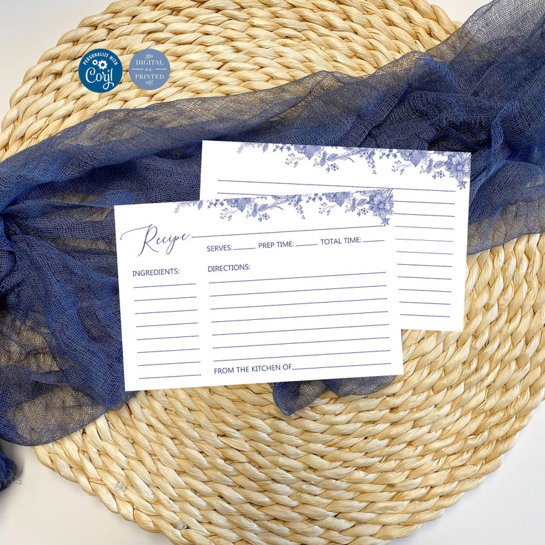 May include: Two white recipe cards with blue floral borders. The top card has the word "Recipe" written in cursive. The bottom card has the words "Ingredients", "Serves", "Prep Time", "Total Time", "Directions", and "From the Kitchen Of" printed on it.