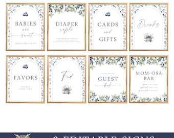 May include: Eight printable signs with a blue and white blueberry design. The signs include the text: "Babies are sweet", "Diaper Raffle", "Cards and Gifts", "Drinks", "Favors", "Food", "Guest Book", and "Mom-osa Bar".