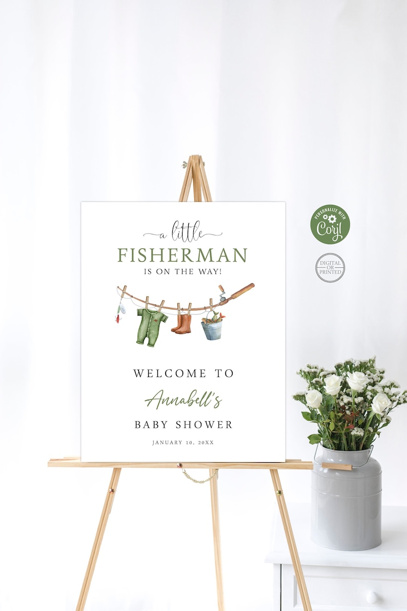 Op de afbeelding: Een wit babyborrelbord met groene tekst die "een kleine VISSER is onderweg!" luidt. Een rij visgerelateerde items hangt aan een waslijn, waaronder een groene baby-romper, bruine laarzen, een hengel en een emmer. Het bord zegt ook "Welkom op Annabell's Babyborrel" en "10 januari 20XX".