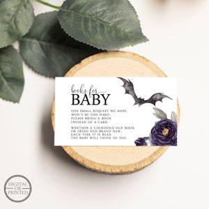 May include: A white card with black text that reads "books for baby". The card has a black bat and purple flowers on it. The text reads "One small request we hope won't be too hard. Please bring a book instead of a card. Whether a cherished old book or fresh and brand new, each time it is read the baby will think of you."