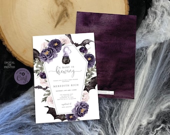 May include: A baby shower invitation card featuring a coffin-shaped frame, dark purple and light pink floral illustrations, and black bats. The text reads A BABY IS brewing, honoring Meredith Rich, with event details and a small cauldron graphic.
