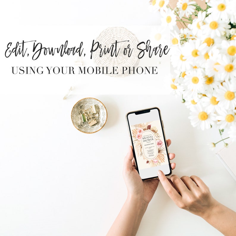 May include: A mobile phone displaying a digital invitation for a bridal shower. The invitation features a floral design with dried grasses and the text "Bridal Shower". The phone is being held by a person's hands on a white surface.