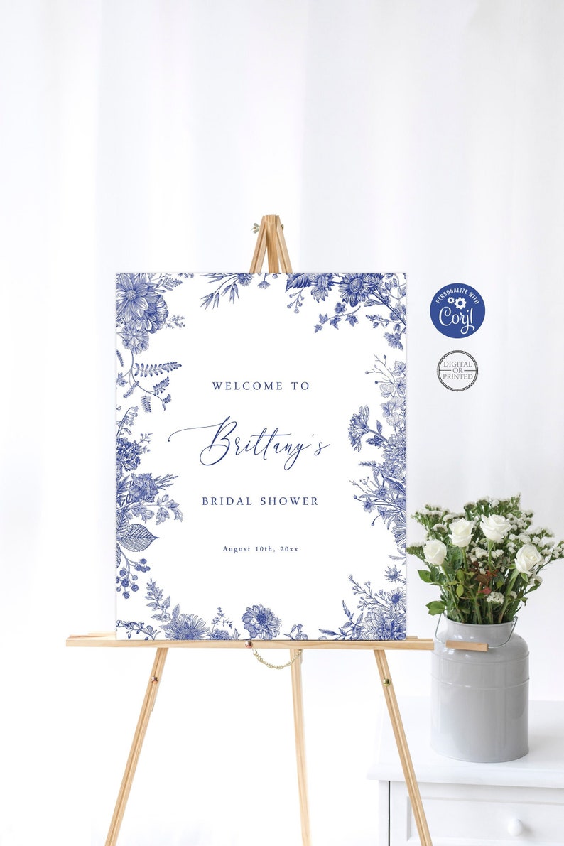 Puede incluir: Un cartel de bienvenida blanco con un borde floral azul y el texto "Bienvenido al Bridal Shower de Brittany el 10 de agosto de 20xx".