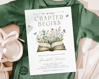 May include: A white rectangular baby shower invitation card featuring the text A NEW CHAPTER BEGINS, an illustration of an open book with colorful wildflowers growing from the pages, and small butterflies, placed on a dark green ribbed bodysuit.