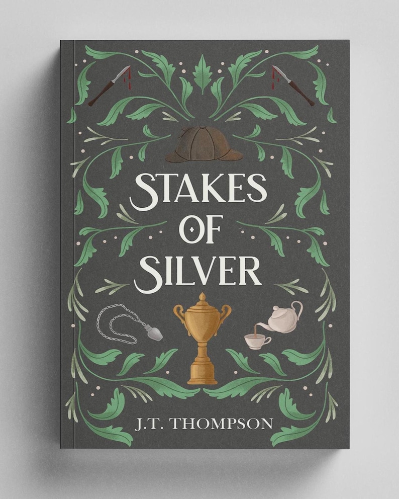 Op de afbeelding: Een boek getiteld Stakes of Silver door J.T. Thompson met een donkergrijze kaft voorzien van groene bladranken, een bruine jagershoed, twee bebloede scalpels, een zilveren ketting, een gouden trofee en een witte theepot die thee inschenkt.