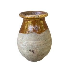 Könnte beinhalten: Eine kleine, runde, braune und graue Keramikvase mit einem glasierten Oberteil.