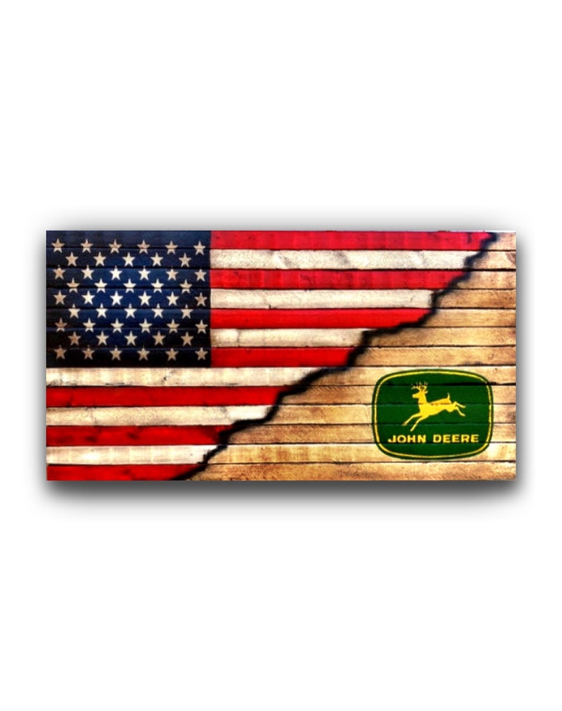 May include: A rectangular wooden sign with the American flag on the left and the John Deere logo on the right. The flag is red, white, and blue, and the logo is green and yellow. The sign has a distressed, rustic look, with a split down the middle.