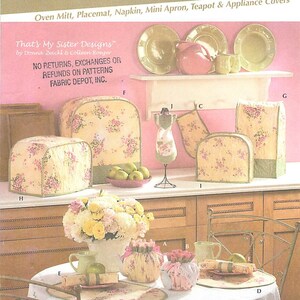 May include: A Simplicity 4341 sewing pattern envelope for kitchen accessories including an oven mitt, placemat, napkin, mini apron, teapot, and appliance covers. The cover features a floral fabric design on various kitchen items.