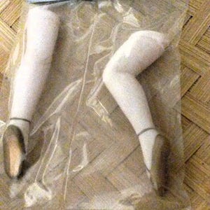 May include: A pair of porcelain doll legs with ballet slippers. The legs are 64mm (2 1/2 inches) long. The package says "Porcelain Lady Legs w/ Ballet Slippers 162-35 64MM (2 1/2") 1 PR".