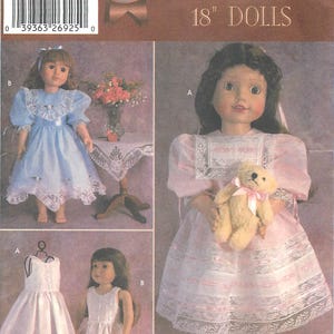 May include: A Simplicity sewing pattern for 18 inch dolls. The pattern includes instructions for making two dresses, one in light blue with lace trim and the other in pink with lace trim. The pattern also includes a teddy bear.