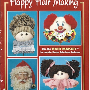 May include: A book cover titled "Happy Hair Making" with four doll heads showcasing different hairstyles. The cover is red with white text and blue squares. The text "Use the HAIR MAKER to create these fabulous hairdos" is also included.