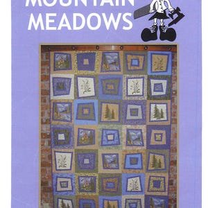 May include: A quilt pattern titled "Mountain Meadows" by Little Miss Sloppy. The quilt design features squares with landscape and floral motifs in shades of blue, green, and tan. The image includes a cartoon illustration of a girl.