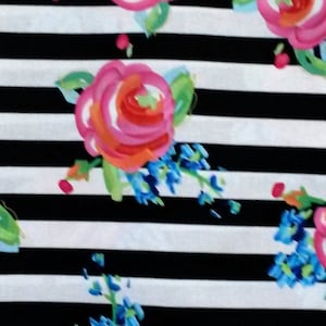 May include: Black and white striped fabric with a floral pattern. The flowers are pink, orange, and blue.