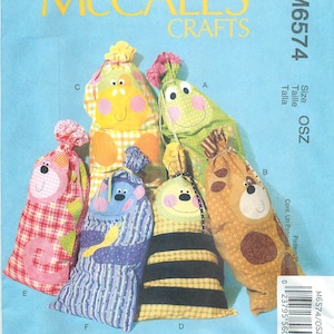 May include: Sewing pattern for five different stuffed toy bags. The bags are shaped like animals and have different patterns and colors. The pattern is called McCall's Crafts M6574 and is for size OSZ.