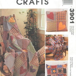 May include: A McCall's Crafts sewing pattern for a quilt and pillows. The pattern is for a patchwork quilt with hearts and a pillow with stars. The pattern is called "Cont. Un Patron de Costura" and is number 3901.