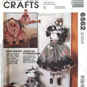 May include: McCall's Crafts pattern 6562 for fabric chickens and cows. The envelope displays finished draft busters measuring 25 inches tall and 3 inches high. The designs feature chickens in red plaid and a cow in black and white fabric with floral accents.