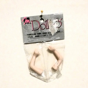 May include: A package of two porcelain fairy doll arms, 44mm (1 3/4") long, for doll making or repair. The package is labeled "m Dolls" and "Porcelain Fairy Arms Slim 173-42 44mm (1 3/4") 113".