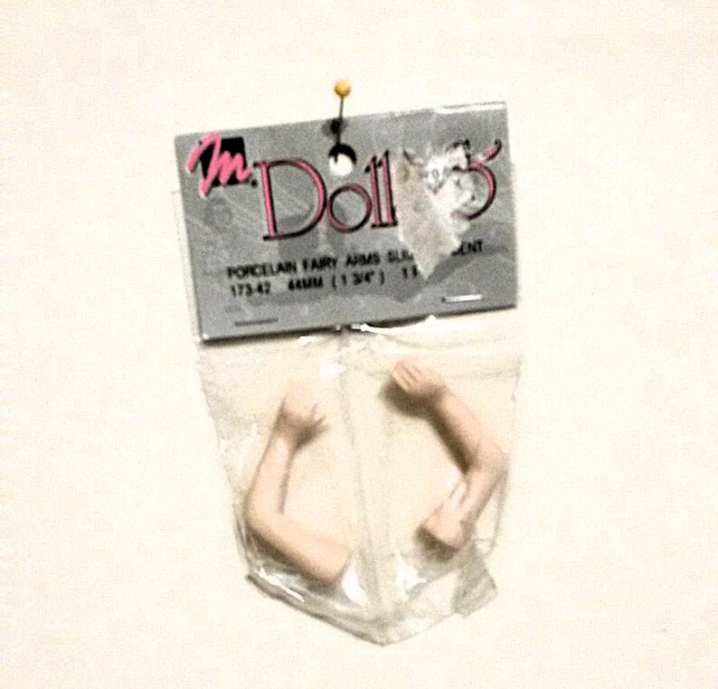 May include: A package of two porcelain fairy doll arms, 44mm (1 3/4") long, for doll making or repair. The package is labeled "m Dolls" and "Porcelain Fairy Arms Slim 173-42 44mm (1 3/4") 113".
