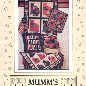 May include: A quilting pattern for a quilt featuring a design of cats with a red, white, and blue color scheme. The pattern is titled "Alley Cats" and is from "Mumm's The Word".