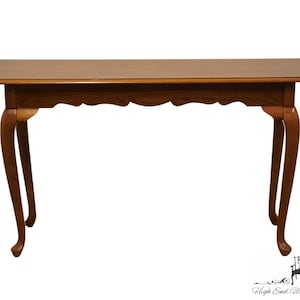 May include: A brown wooden console table with a carved edge and cabriole legs.