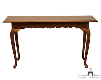 May include: A brown wooden console table with a carved edge and cabriole legs.