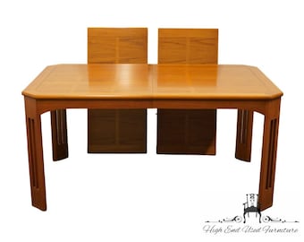 May include: A rectangular, wooden dining table with two leaves. The table is made of a light brown wood with a natural finish. The table has a simple, modern design with straight legs and a rectangular top. The table is in good condition and has a few minor scratches.