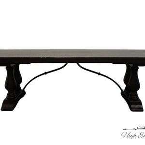 May include: Dark brown rectangular dining table with ornate, dark wood legs and a curved metal support. The table is a substantial piece of furniture, suitable for a dining room or kitchen. The table is set against a white background.