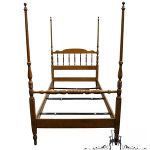 May include: A light brown wooden four-poster bed frame featuring tall, slender posts with decorative turned detailing. The headboard consists of a series of vertical spindles topped by a curved wooden rail, while the footboard has a horizontal rail.