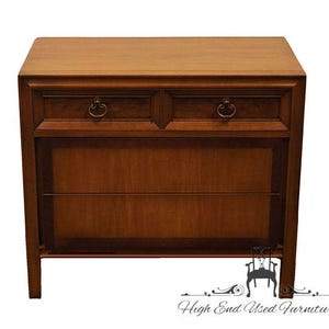 May include: A vintage wooden dresser with two drawers and a lower cabinet. The dresser has a dark wood finish and brass hardware.