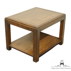 May include: A dark brown wooden end table with a square top and a lower shelf. The table has a simple, modern design with clean lines.
