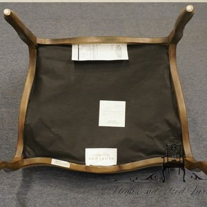 Puede incluir: Una silla de madera marr&oacute;n con un asiento de tela negra. La silla tiene un respaldo curvo y un dise&ntilde;o simple.