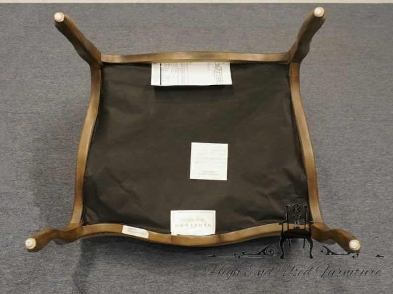 Puede incluir: Una silla de madera marr&oacute;n con un asiento de tela negra. La silla tiene un respaldo curvo y un dise&ntilde;o simple.