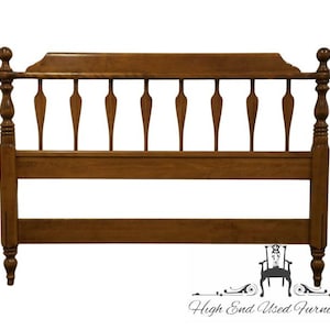 May include: A wooden headboard with a warm brown finish. The headboard features a series of vertical spindles with a decorative top rail and rounded finials. The design is classic and elegant, suitable for a bedroom.