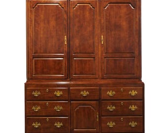 May include: A large, antique-style, mahogany wood cabinet with three doors and a lower section with drawers and a cabinet door. The cabinet has brass hardware and a decorative top.