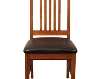 Puede incluir: Una silla de comedor de madera con un asiento tapizado en negro. La silla tiene un respaldo de listones y un diseño simple y tradicional.