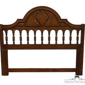 May include: A brown wooden headboard with a carved design and a rounded top. The headboard has a series of vertical spindles with rounded tops. The headboard is made of solid wood and has a traditional style.