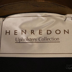 Puede incluir: Una etiqueta blanca con texto negro que dice "HENREDON Upholstery Collection".