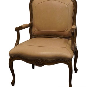 Puede incluir: Un sill&oacute;n de cuero marr&oacute;n con un marco de madera tallada y un respaldo capiton&eacute;. La silla tiene un dise&ntilde;o cl&aacute;sico y ser&iacute;a una gran adici&oacute;n a cualquier sala de estar o comedor.