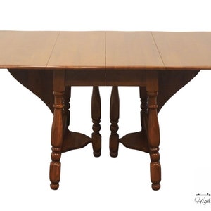 May include: A brown wooden drop leaf table with turned legs and a rectangular top.