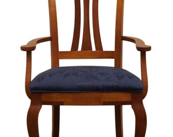 Puede incluir: Una silla de comedor de madera con un asiento tapizado en azul. La silla tiene un respaldo y brazos curvos, y las patas son cabriole.