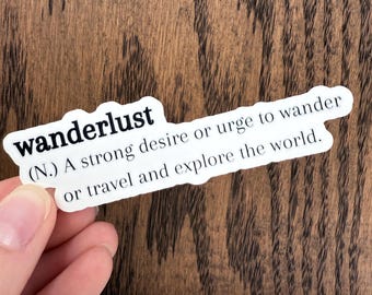 May include: A white sticker with black text that reads "wanderlust (N.) A strong desire or urge to wander or travel and explore the world."