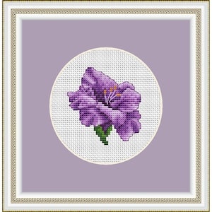 May include: A purple flower with yellow center is embroidered on a white background within a circular frame. The frame is on a light purple background.