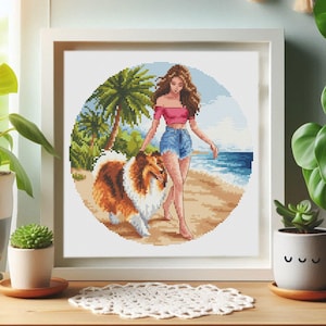 Könnte beinhalten: Ein Kreuzstichmuster mit einer Frau in einem rosafarbenen Oberteil und Jeans-Shorts, die mit einem braunen und weißen Hund am Strand spazieren geht. Der Hintergrund zeigt eine tropische Szene mit Palmen und blauem Wasser.